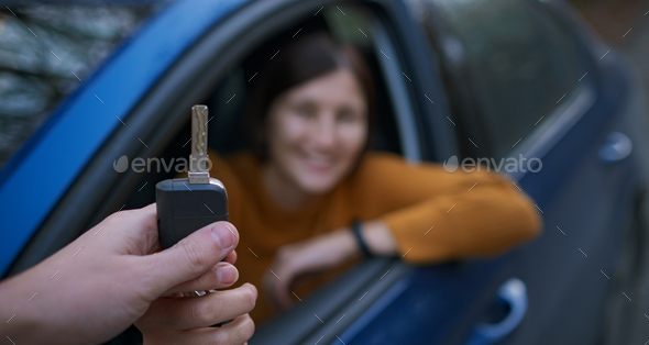 Auto Dealer Giving asian Woman Automobile Key For Test Drive.