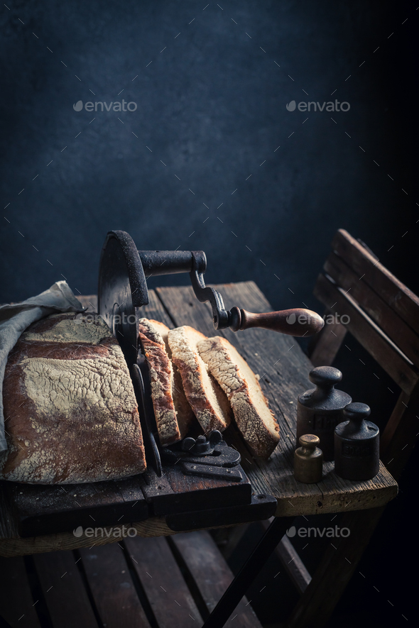 Healthy and tasty loaf of bread with on old slicer.