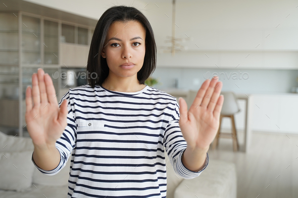 Serious young woman show stop gesture by palms, sign of prohibition, disagreement, rejection at home - Stock Photo - Images