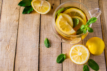 Herbal tea with lemon and mint on a wooden background. 
