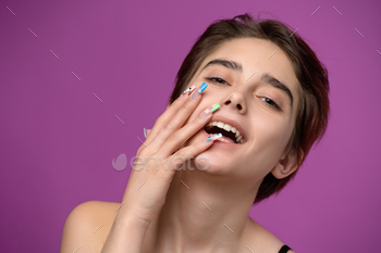 Pretty girl portrait with short haircut and extravagant nail art