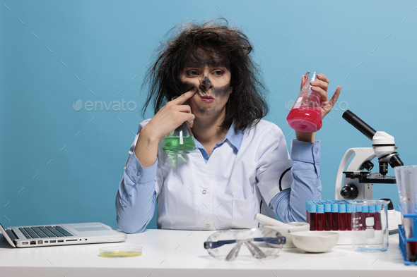 Foolish goofy looking maniac scientist having beakers filled with chemical compounds.