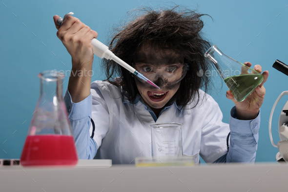 Foolish silly female lab worker with pipette and glass jar mixing toxic chemical compounds to create