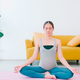 Beautiful young Asian pregnant woman in sportswear is doing yoga at home. - PhotoDune Item for Sale