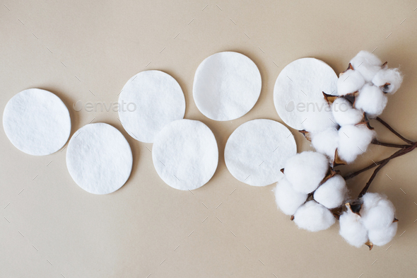 fluffy cotton flower cotton pads on beige background with copy space. hygienic disposable product