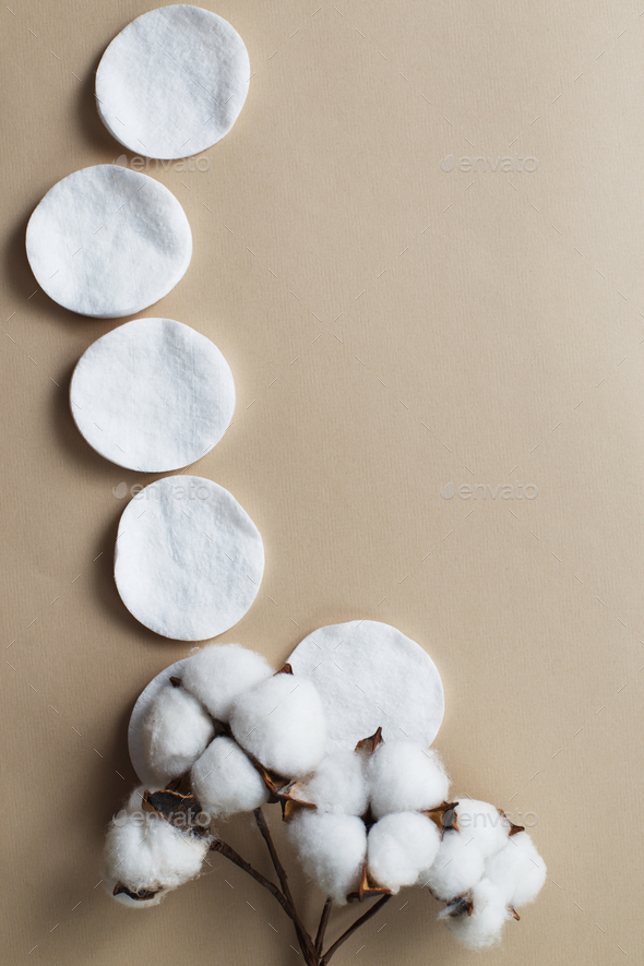 fluffy cotton flower cotton pads on beige background with copy space. hygienic disposable product