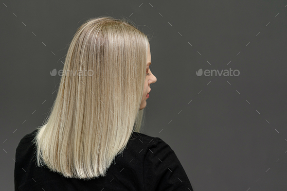 Blonde model with straight hair, look from behind. Hair bleaching result. Copy space