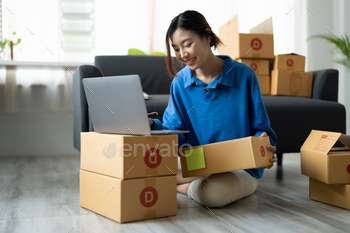 Shipping shopping online, startup small business owner writing address on cardboard box at