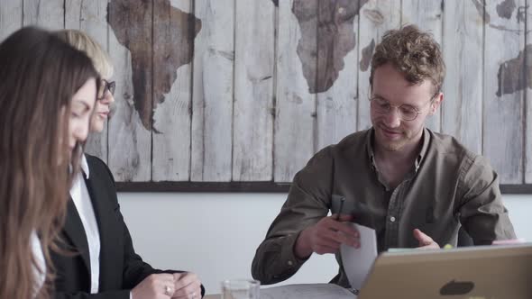 The Collegues Are Working in the Office Sitting at the Conference Table alt