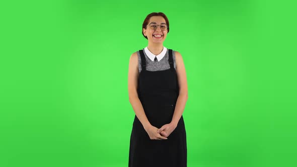 Funny Girl in Round Glasses Is Laughing While Looking at Camera. Green Screen alt
