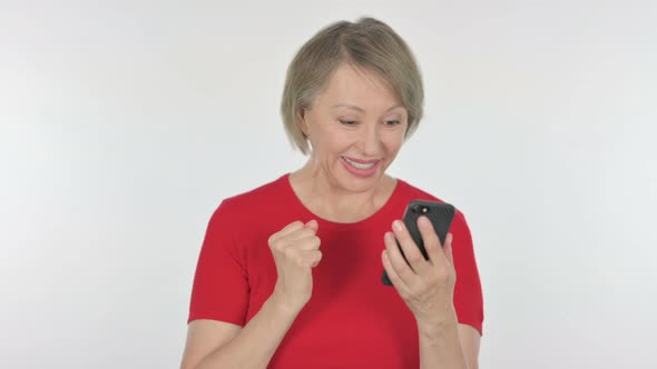 Old Woman Celebrating on Smartphone on White Background alt