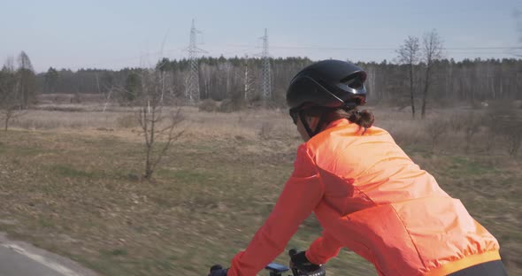 Cyclist rides on bike. Woman cycling. Triathlete riding a bicycle. Female pedalling on road bike alt