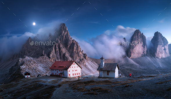 Mountains in fog with beautiful house and church at night