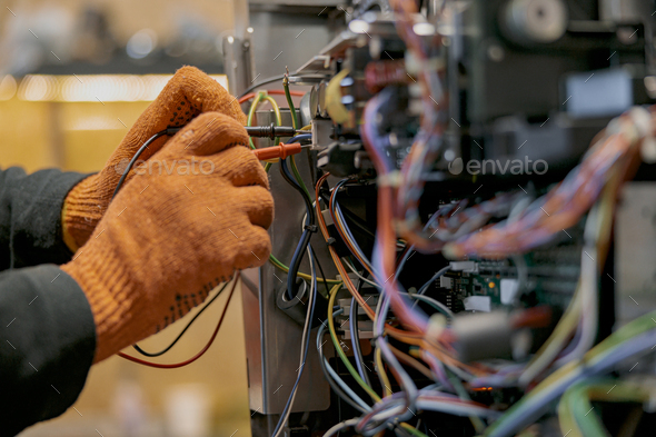 Male electrician hands repairing coffee machine in workshop