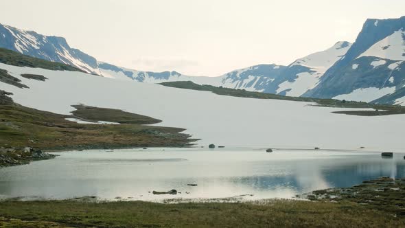Beautiful calm lake by the white mountains of Sylarna, Sweden -Wide panning alt