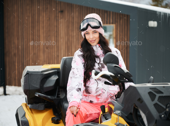 Portrait of beautiful woman posing on offroad four-wheeler ATV.