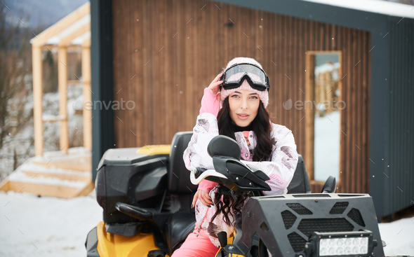 Portrait of beautiful woman posing on offroad four-wheeler ATV.