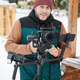 videographer man with camera mounted on gimbal stabilizer equipment in winter. - PhotoDune Item for Sale