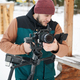 videographer man with camera mounted on gimbal stabilizer equipment in winter. - PhotoDune Item for Sale