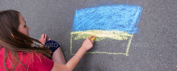 Flag of Ukraine. Chalk drawing on sidewalk. Creative support by children for Ukraine.