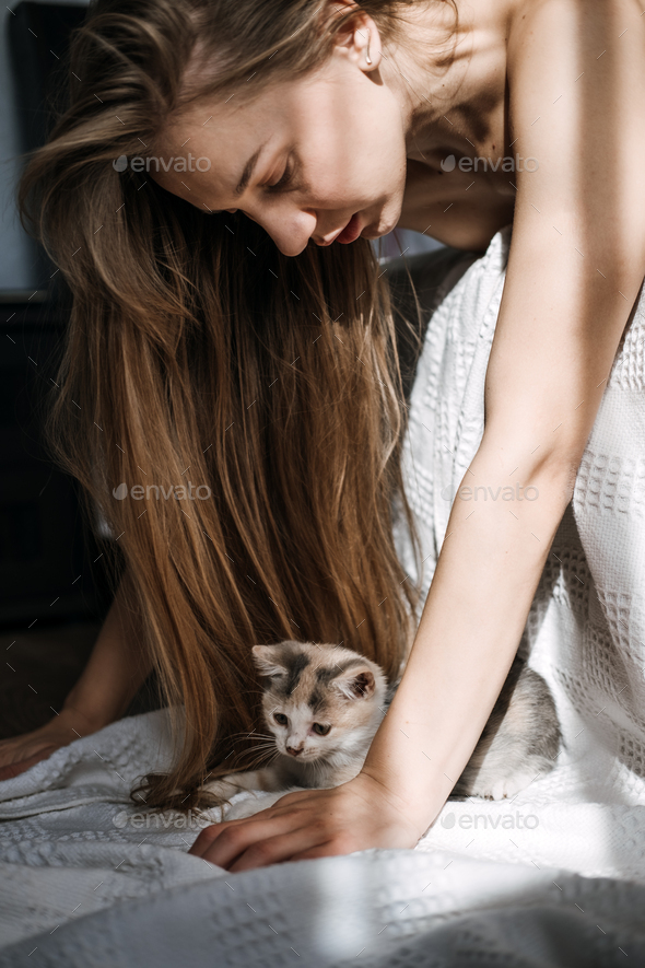 Mindfulness, Being in the present moment, here and now. Young woman play with kitten at home in