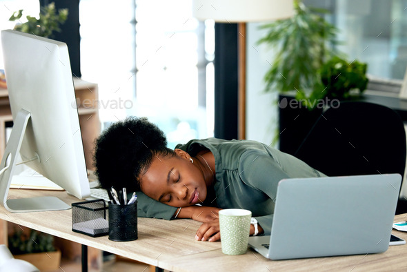 Power naps are helpful for productivity. Shot of a young businesswoman taking a nap at work.