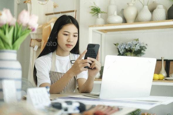 Young asian businesswoman sitting in house inspection product and to contact customers.