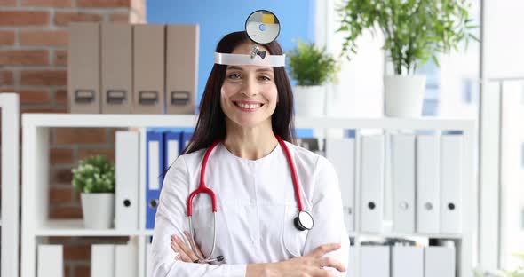 Doctor Otolaryngologist in White Coat and Mirror on Head Closeup alt
