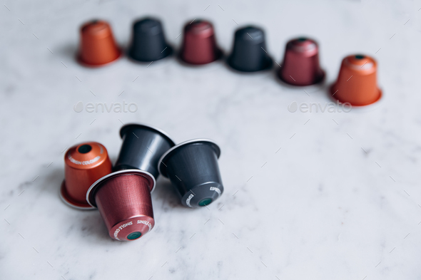 Variety of coffee capsules on white background