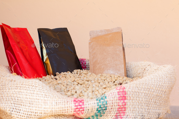 Three coffee packaging bags. Paper bags for coffee on sack full of coffee beans.