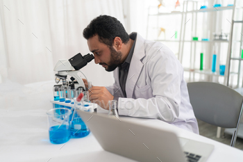 Lab Worker Using Magnifying Glass on Microscope