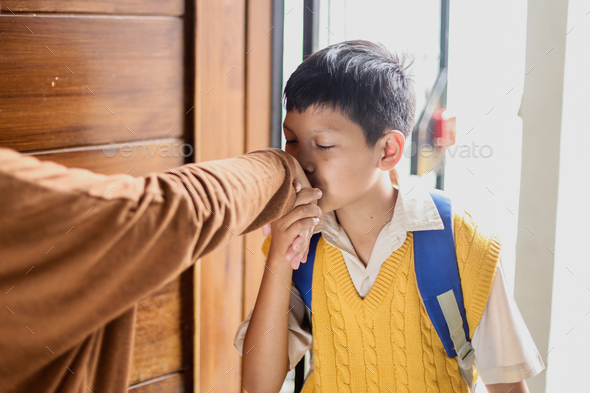 Asian boy going to school, kissing mother\'s hand