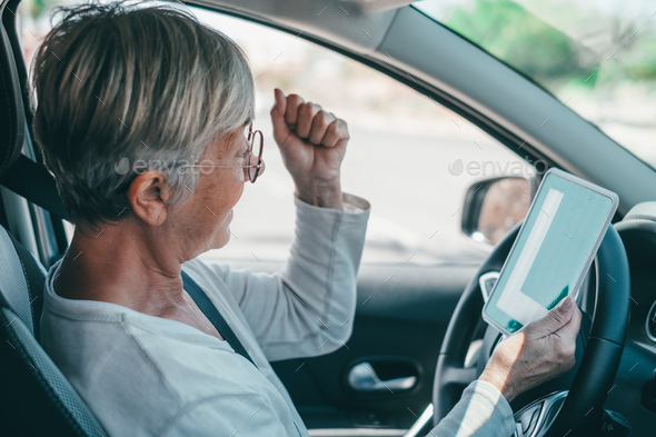 One old woman getting the pass to drive a car at mature age. Senior ...