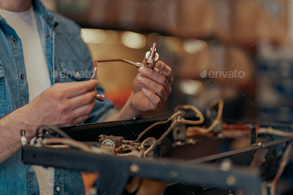 Close up of man hands repairing coffee machine in a workshop