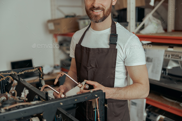 Close up of man repairing coffee machine in a workshop