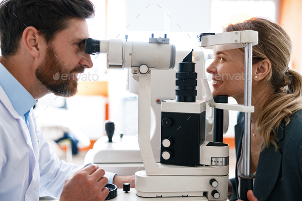 Male ophthalmologist checks a patient\'s vision at an opticians shop or ophthalmology clinic