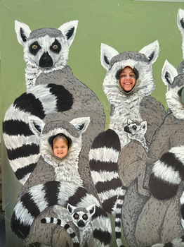 Mom and daughter put their faces into a tantamaresque with painted lemurs