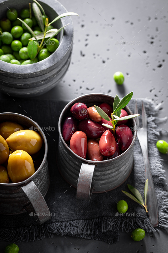 Various types of olives in bowls ready to eat. Stock Photo by Shaiith