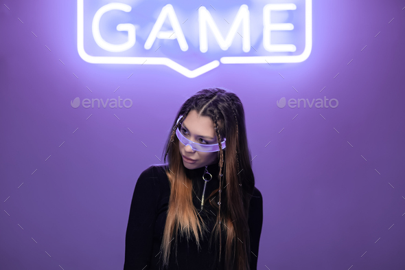 Woman in neon glasses in a neon room with neon game signs
