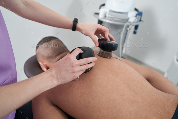 Man receiving vacuum therapy treatment in rehabilitation clinic