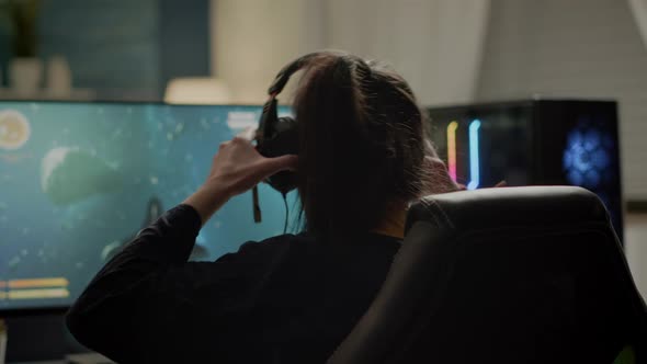 Gamer Streatching Neck and Putting Headphone Before Playing Games alt