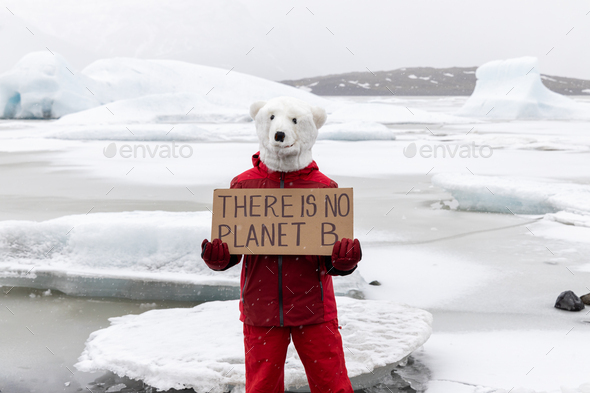Activist on Polar bear mask holding a banner \