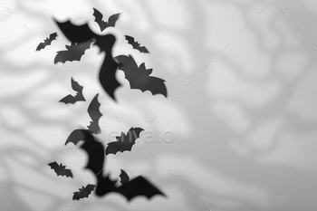 Halloween decoration concept - black paper bats and scary trees shadows background