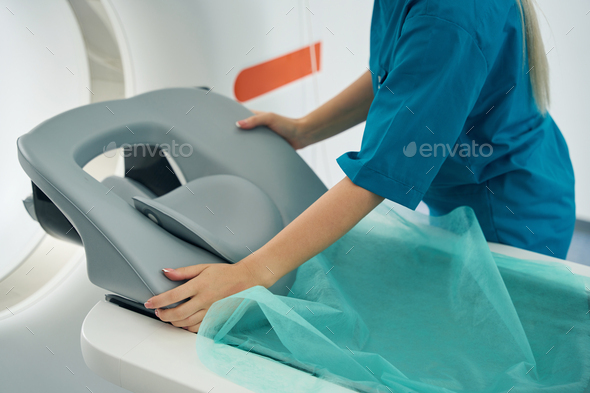 Nurse covers the couch of the CT scanner with sheet