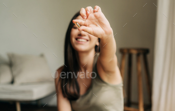 Happy healthy woman recommending omega 3 fish oil and holding out a pill in her hand