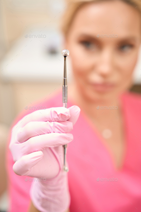 Beautiful woman beautician looking at uno spoon - Stock Photo - Images