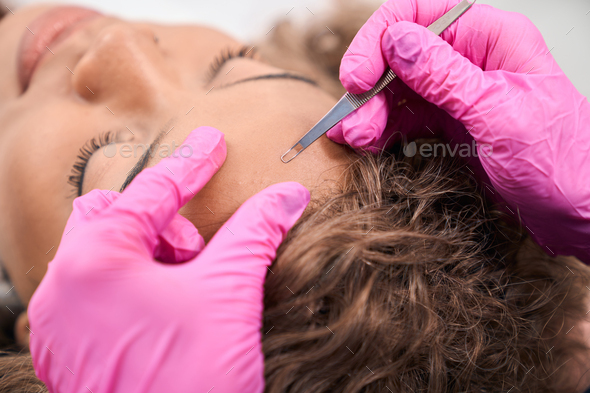Young woman is being cleaned with a spoon uno - Stock Photo - Images
