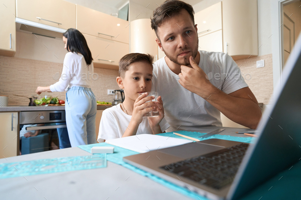 Kid with glass sitting near father, confused with son homework