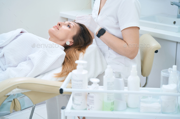 Cosmetologist makes mechanical cleaning of the skin with an uno spoon - Stock Photo - Images