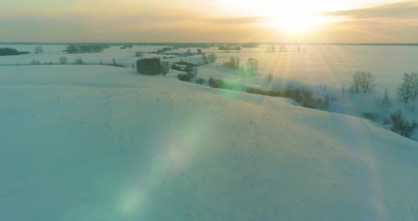 Aerial View of Cold Arctic Field Landscape Trees with Frost Snow Ice River and Sun Rays Over Horizon alt